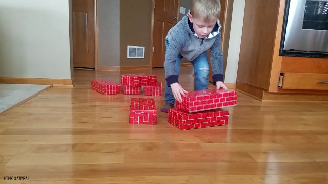 Balance activity that is so much fun! Use cardboard blocks to play these balance games that any kid or adult will love. This gross motor game can easily be adapted to increase or decrease the challenge! #balance #grossmotor 